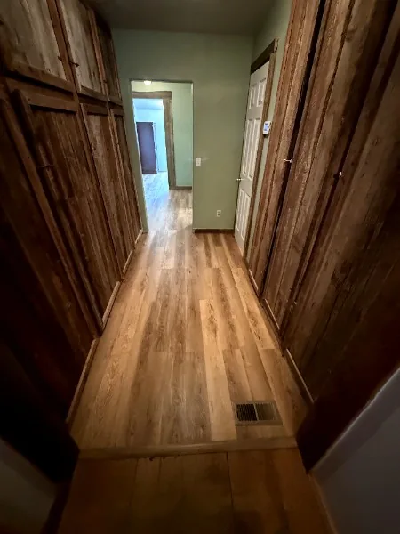 Wood-paneled hallway with new wood-look flooring